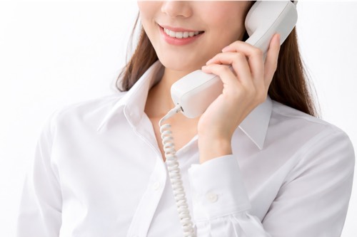 白い電話を持つ女性